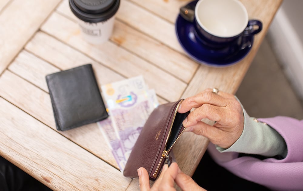 Hands-opening-purse-at-cafe