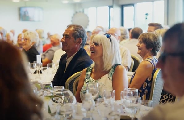 A few Goodmans clients smiling at a dining table