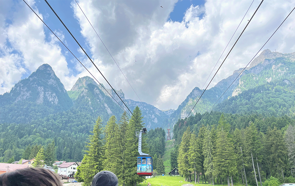 A cable car ascending towards a mountain range