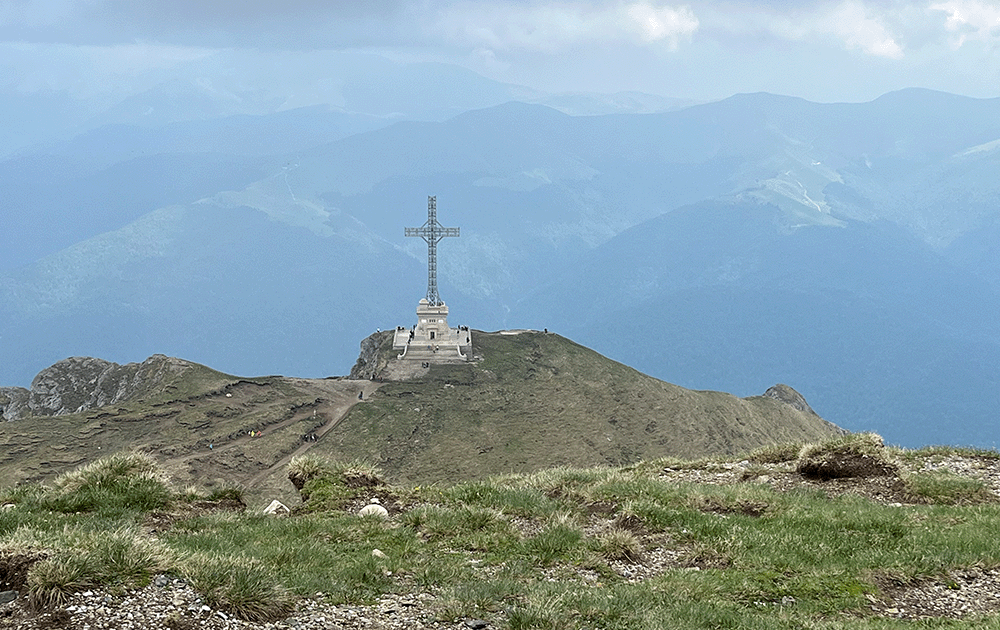 A cross monument on top of a mountain 