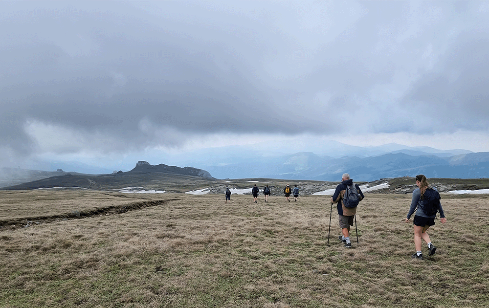 Hikers on a plateau with some snow