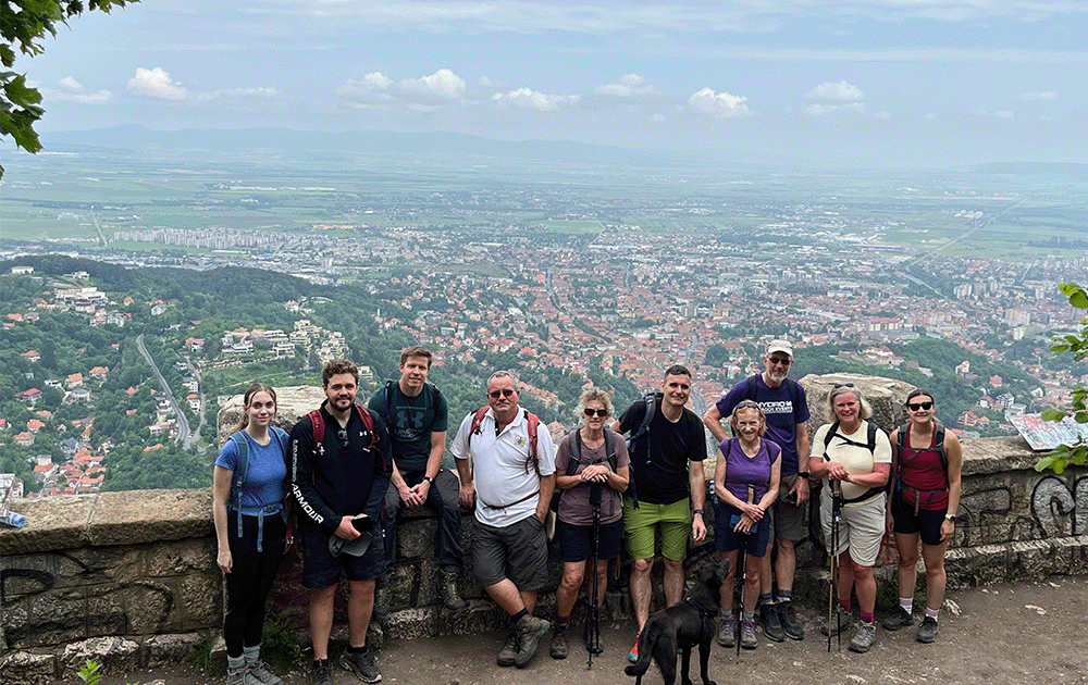 A group standing in front of a view of a city below