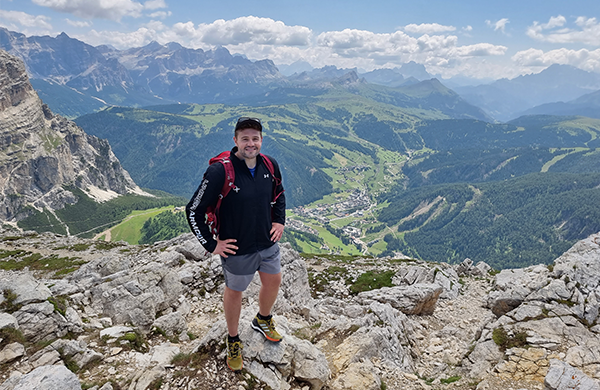 Sam with a sweeping view of the Dolomites mountains in Italy